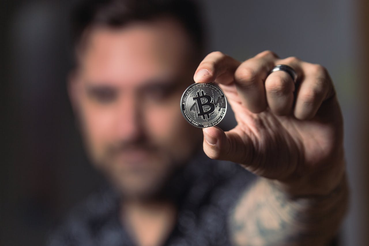 services-02 Adult male hand holding a Bitcoin, showcasing cryptocurrency focus indoors.