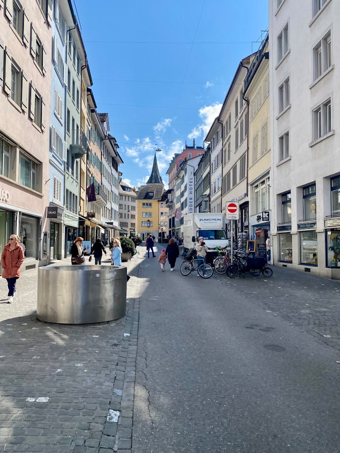A vibrant street in Zurich captures the essence of Swiss urban life with shops and people.